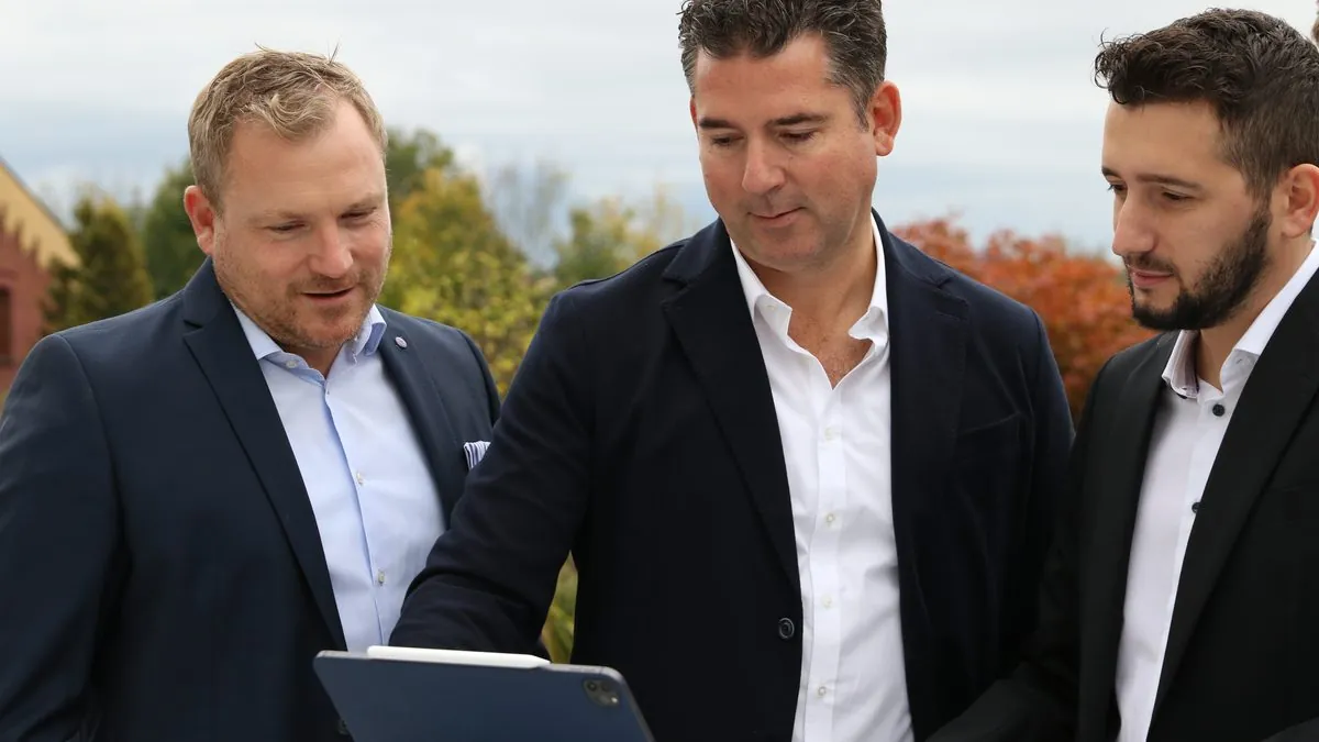 Drei Berater von IcosMedia im Gespräch über ein Tablet